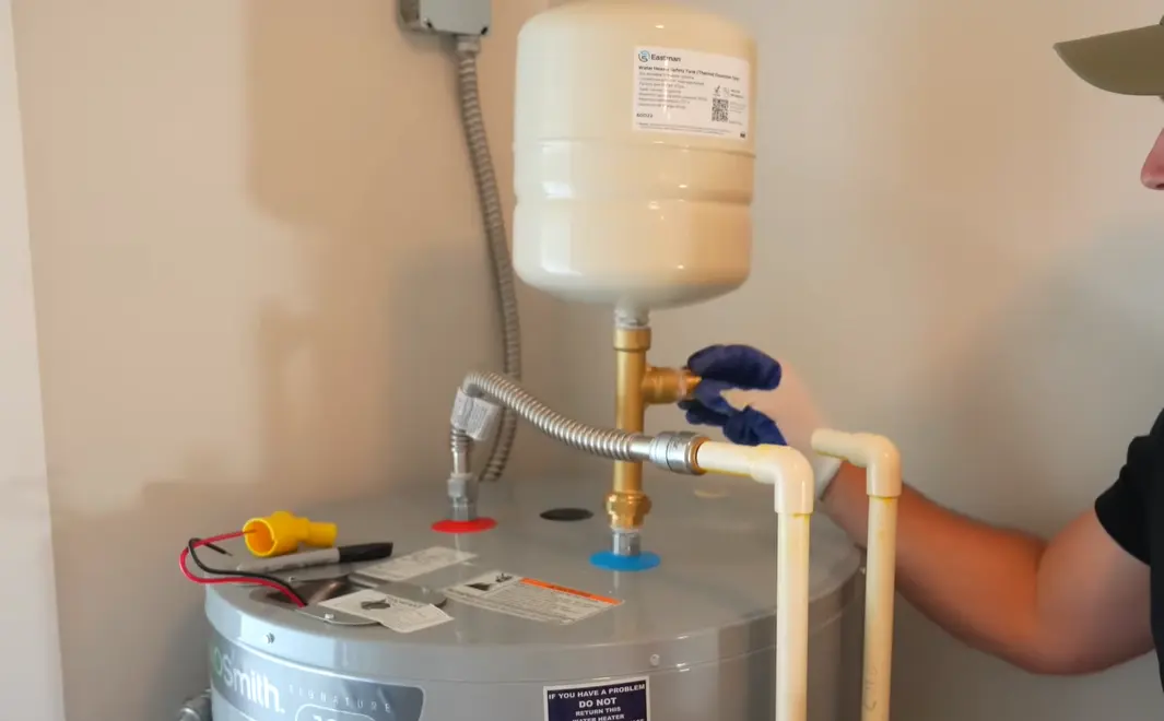 Water heater repair in Fort Collins — technician diagnosing a gas unit with heavy sediment buildup